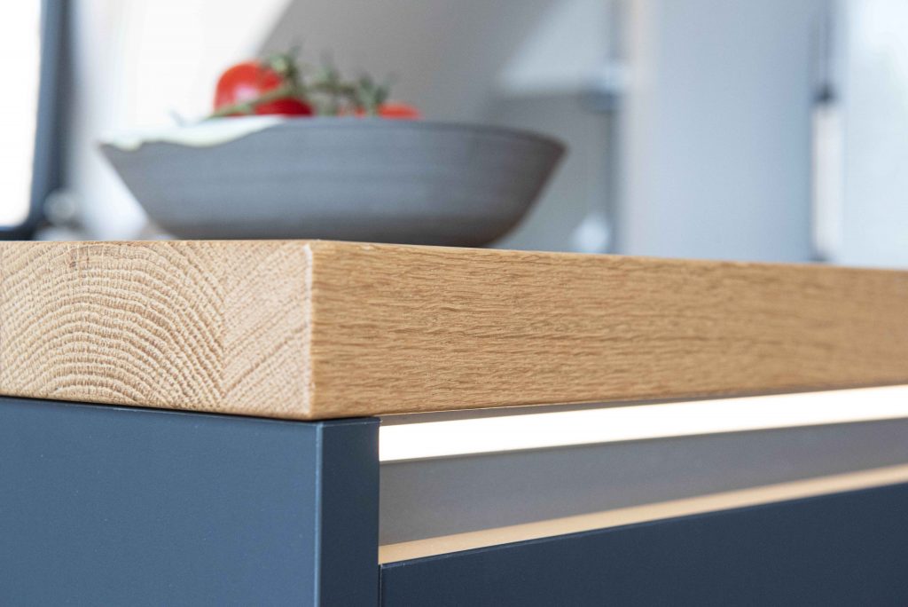 Küchenschränke nach Maß an Dachschräge angepasst mit nahtloser Arbeitsplatte